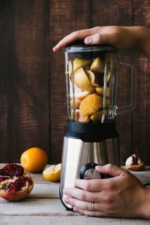 Blender with various fruit wooden background