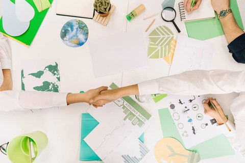 High angle view two businesspeople shaking hands desk