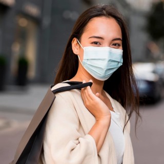 Woman with medical mask out sale shopping spree with shopping bag