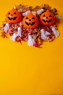 Overhead view of orange Halloween pumpkins on a background of yellow