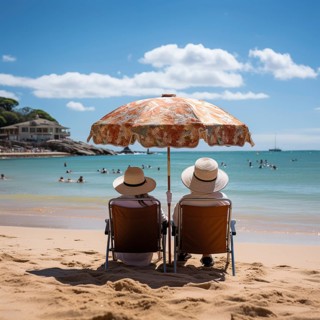 Retired couple sitting on sun loungers under an umbrella and looking at the sea