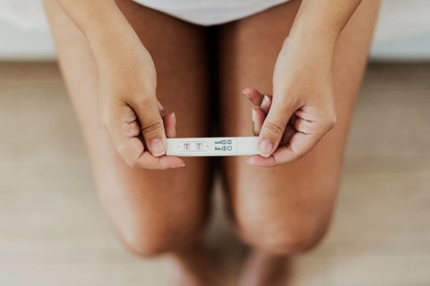 Top view hands holding positive pregnancy test