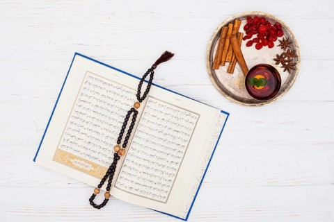 Cup tea near spices tray book with beads