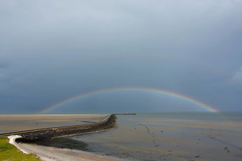 View from the radar tower of Minsener Oog Island onto the jetty with rainbow