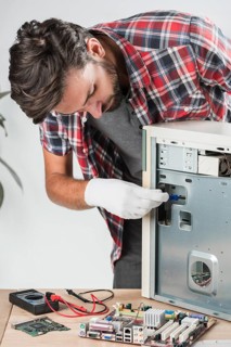 Young male technician examining computer workshop
