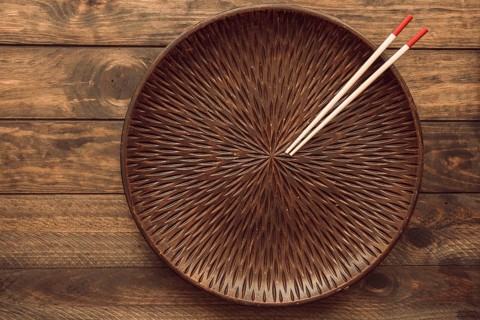 Empty round plate with two wooden chopsticks table