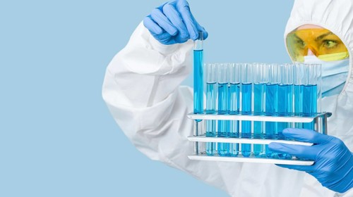 Scientist looking blue chemicals