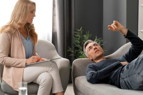 Mid shot man laying couch therapy cabinet near counselor