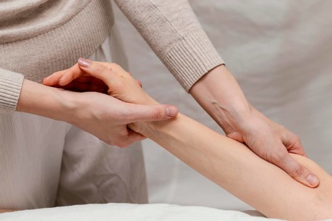 Close up therapist massaging patient s arm