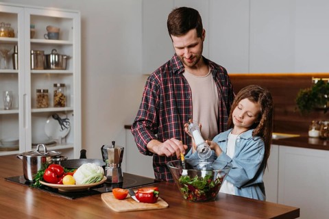 Front view father with daughter preparing food kitchen