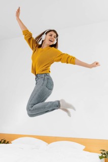 Full shot woman jumping with headphones