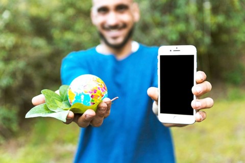 Man holding globe with leaf smartphone