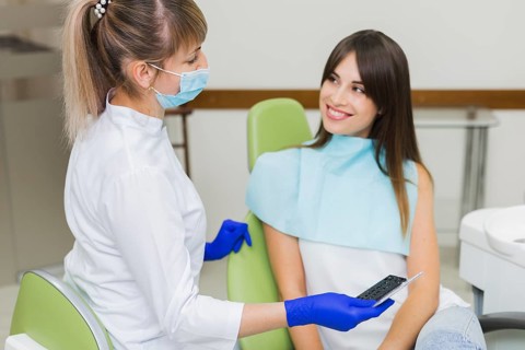 Dentist happy patient looking each other