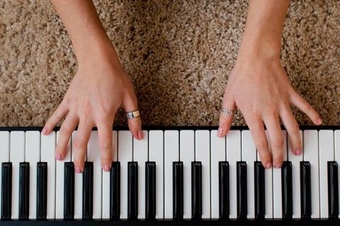 Top view female musician playing piano keyboard