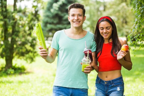 Young couple with healthy food standing garden