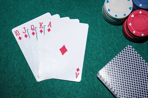 Royal flush playing cards with casino chips poker table