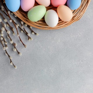 Top view colorful easter eggs basket with flowers copy space