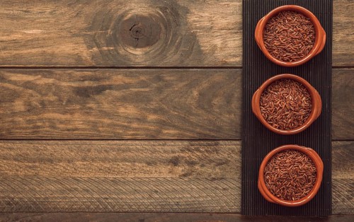 Uncooked red jasmine rice bowls placemat wooden background