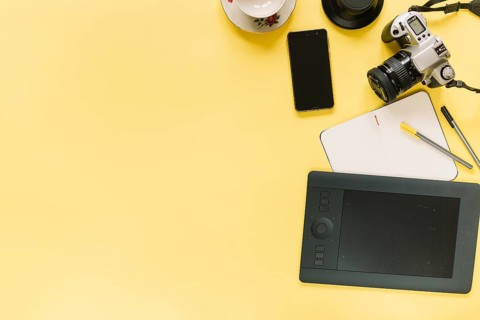 Digital graphic tablet camera cellphone with stationery yellow background