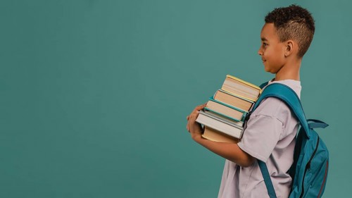 Side view child holding pile books