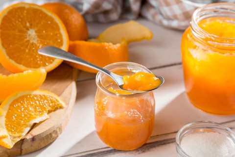 High angle clear glass jar with orange jam