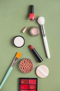 High angle view various makeup products green background