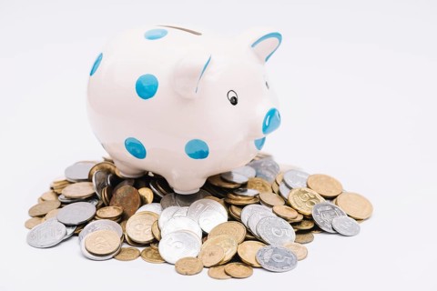 Piggybank many coins white background