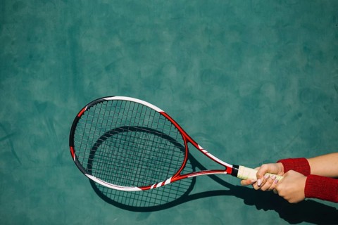 Woman holding tennis racket both hands