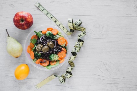 Measuring tape near salad fruits