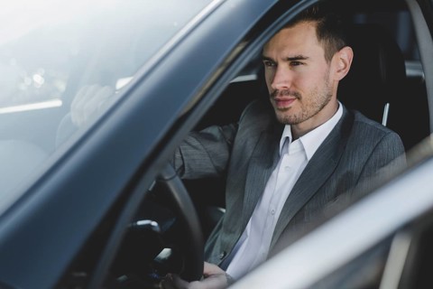 Close up young handsome businessman sitting car seat