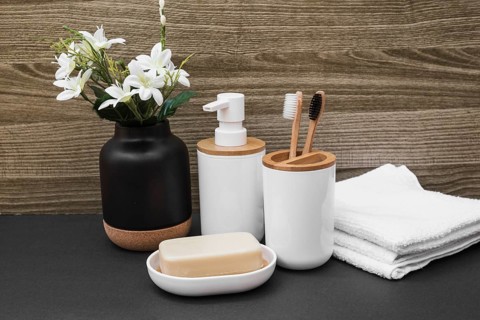 Soap toothbrush cosmetic bottle towel white flower vase black surface
