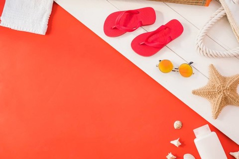 Flip flops near towel with starfish bottle with sunglasses among seashell