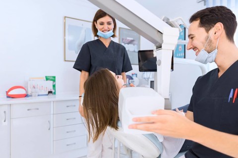 Male dentist scanning female patient s teeth with x ray machine