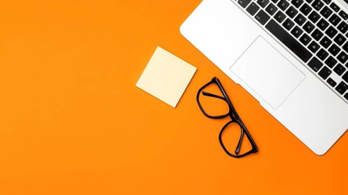 Top view desk concept with orange background
