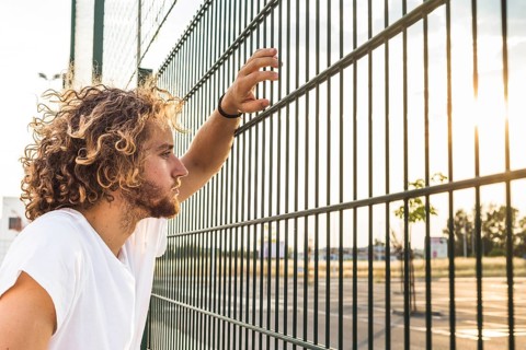 Man looking through fence