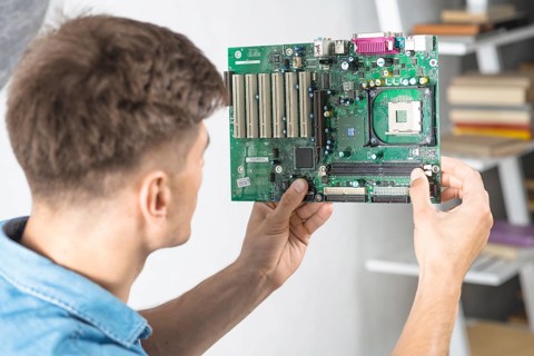 Young it technician looking motherboard
