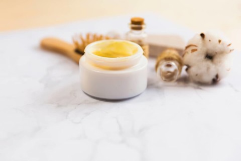 Close up beauty cream bottle cotton flower plant