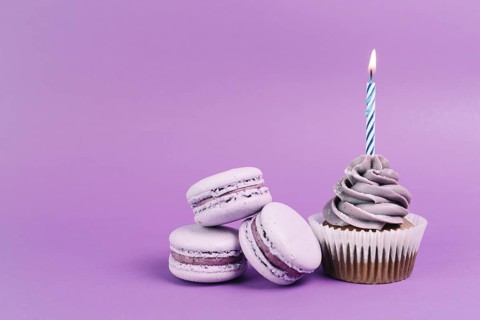 Macaroons near cupcake with candle