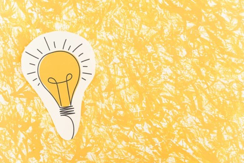 Hand drawn light bulb cut out yellow pattern background