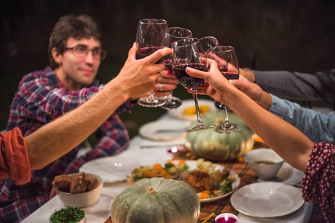 People clinking glasses table