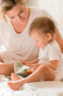 Portrait mom reading baby bed