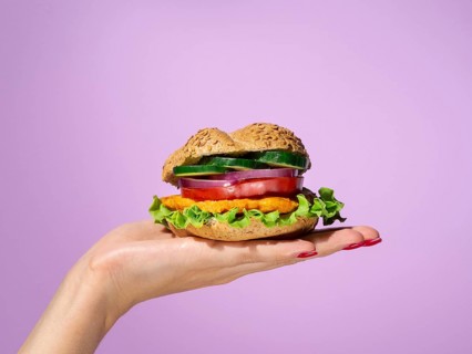 Woman holding tasty burger her palm