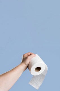 Front view hand holding toilet paper with copy space