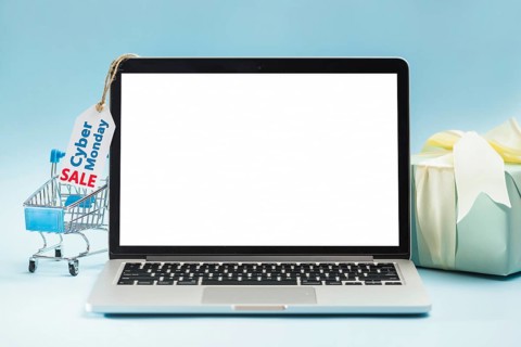 Laptop near shopping trolley tag gift box