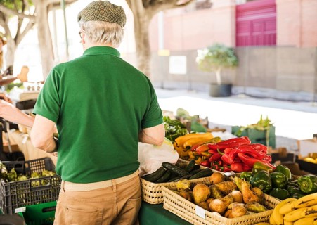 Rear view senior man standing vegetable fruit stall