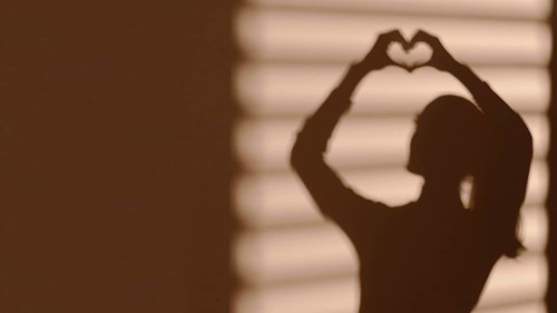 Shadow woman making heart