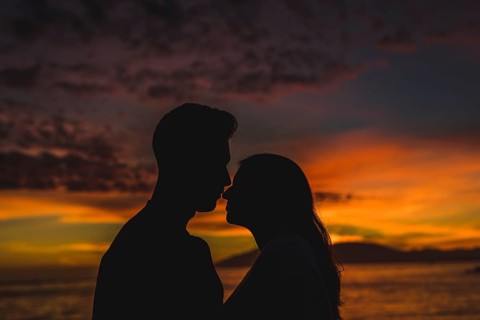 Young couple standing sea shore night