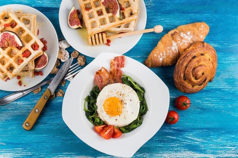 Waffles with fig baked pastries egg fried egg white plates blue textured backdrop