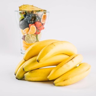 Bananas near glass with fruits