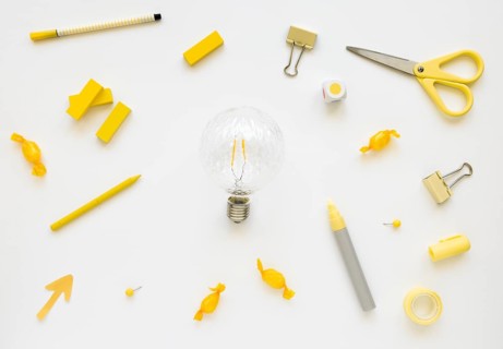 Fluorescent bulb surrounded by various stationeries candies